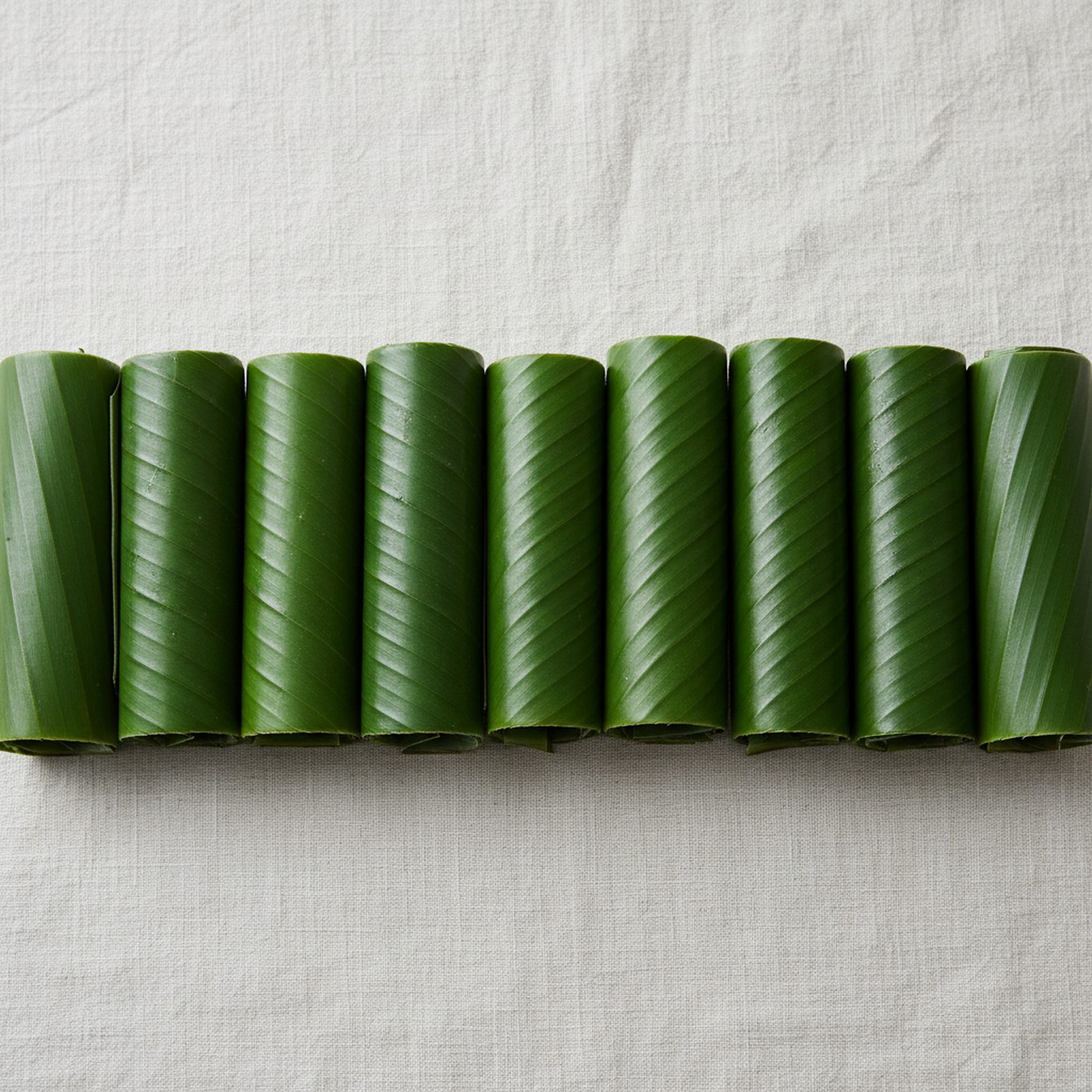Rolled fresh banana leaves in a row — TapakNusa export catalogue banner